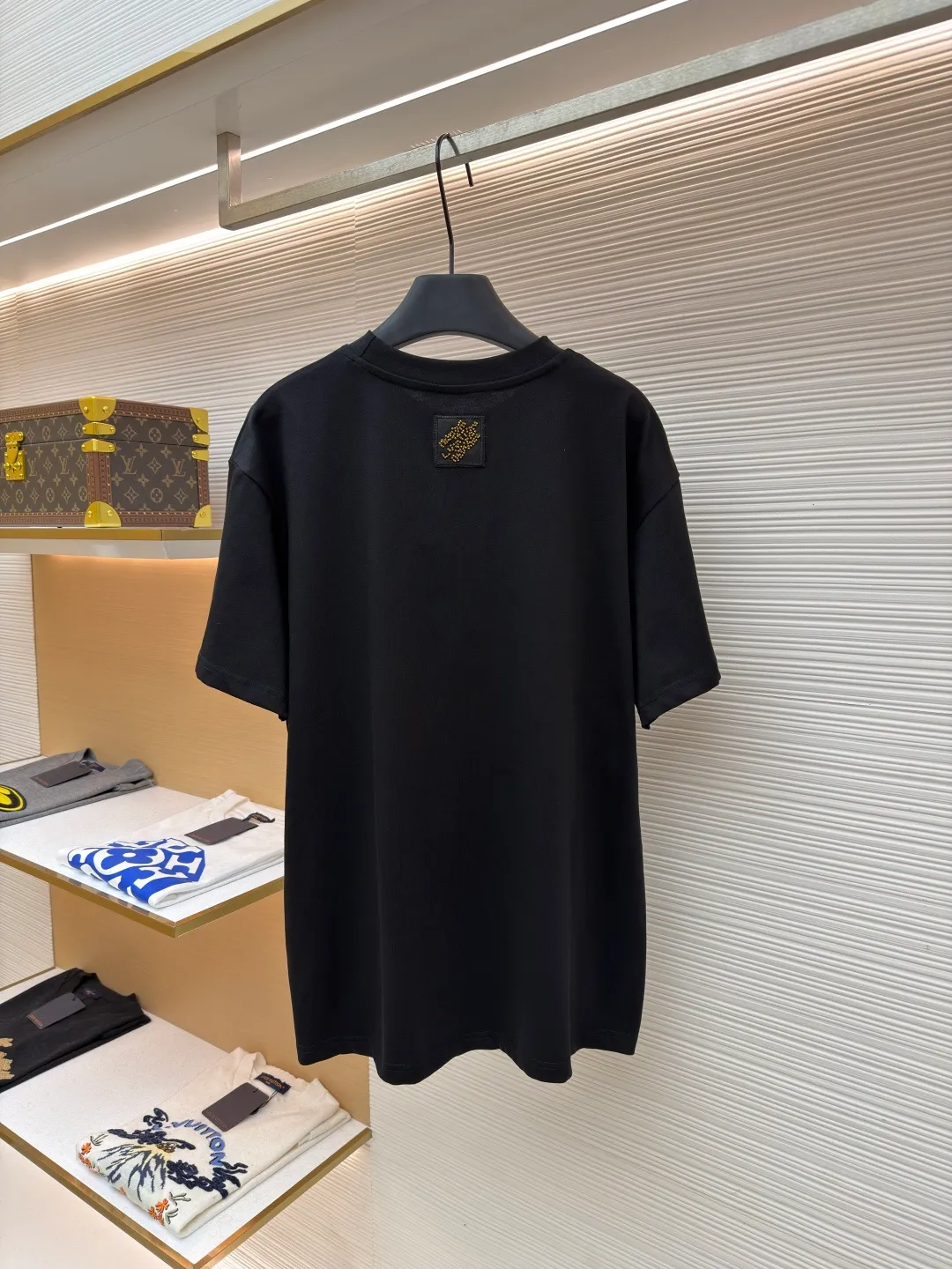 LOUIS VUITTON cotton round neck embroidered Vuitton signature logo short sleeves ●Original version: purchased and developed for 12300 ●Item number: 1682273-A10 ●Fabric: cotton fabric ●Technology: embroidery production ●Color: black ●Version: fitted version ●Weight: about 295 grams ●Size: S-M-L-XL ●Description: This white short-sleeved T-shirt is made of high-count combed cotton fabric and has been treated with pre-washing technology. It has a soft and skin-friendly touch and is not easy to deform. The silhouette of the shirt is a loose shoulder design, which meets the needs of modern casual wear. The core decoration area on the chest uses hand-beading and bronzing technology, and uses metallic gold sequins and embroidery threads intertwined to outline a three-dimensional letter pattern. The sequins are layered and inlaid, and each one is manually positioned and fixed by craftsmen to ensure a regular texture and uniform gloss. The edges of the letters are sewn with matte silk thread to form a visual contrast between gold and matte, while reinforcing the decorative structure to avoid falling off during wear. The neckline uses double-needle hemming technology and is matched with ribbed cuffs of the same fabric. It is durable and fits the neck. The overall craftsmanship combines handicraftsmanship with modern clothing technology, and the details show exquisite texture. The overall wiring is straight and delicate, the fabric is comfortable and soft, and the color is consistent without color difference. It can be matched with the same style to create a fashionable look and control various occasions. Customized accessories, complete with three standards, same style for men and women!